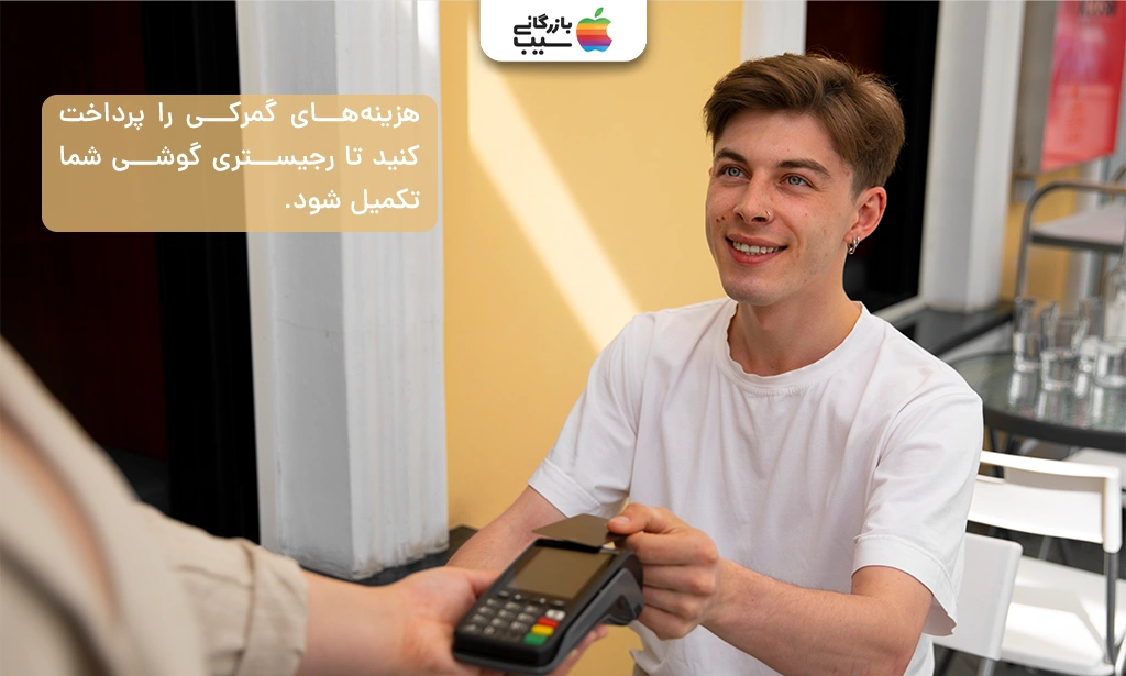 تصویری از فردی که در باجه گمرک هزینههای رجیستری گوشی را از طریق کارت بانکی پرداخت میکند.