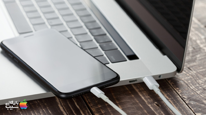 تصویری از یک گوشی اندروید که با کابل USB-C به مک بوک متصل شده است