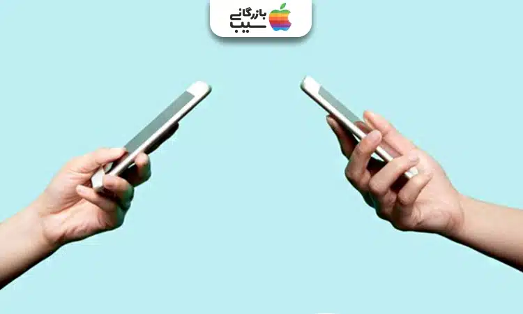تصویر از دو دست که گوشی های هوشمند را در جهت مخالف هم نگه داشته اند.
