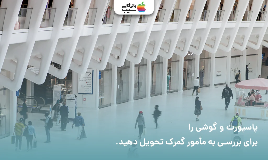 تصویر مأمور گمرک در حال بررسی پاسپورت و جعبه آیفون جهت رجیستر آیفون 15 پلاس