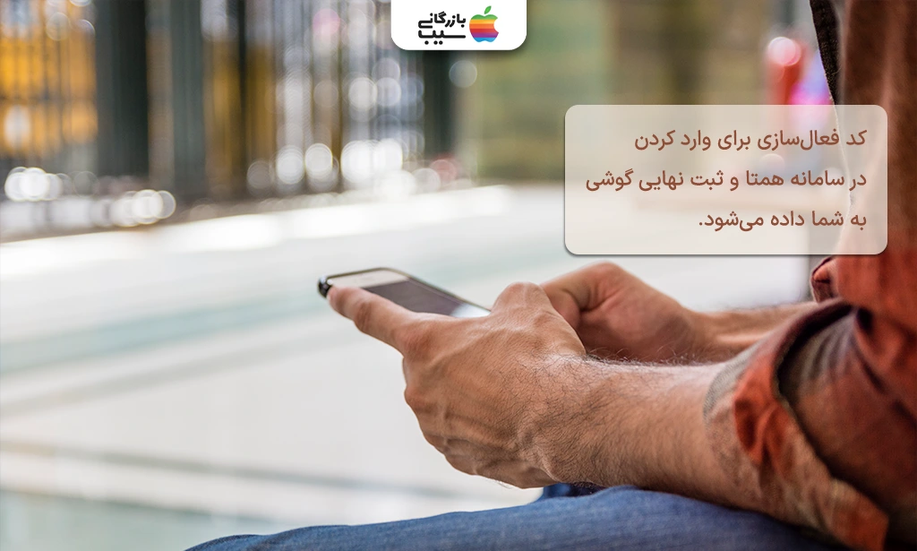 تصویری از فردی که یک گوشی در دست آن است و در حال دریافت کد فعالسازی است.