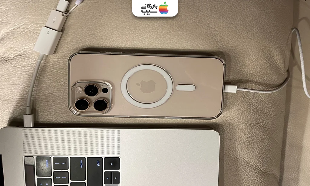 تصویری از یک مک بوک و آیفون 16 پرومکس در حال اتصال با کابل USB-C