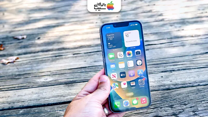 نمای مقایسه‌ای از آیفون 17 پرو مکس و آیفون 14 در حال اجرای چندین اپلیکیشن (مانند ویرایش ویدیو، بازی و شبکه‌های اجتماعی) روی صفحه‌نمایش تقسیم‌شده، با پس‌زمینه‌ای از یک محیط کاری مدرن با مانیتور و کیبورد که تفاوت عملکرد چندوظیفه‌ای و سرعت رم را با وضوح نشان می‌دهد.