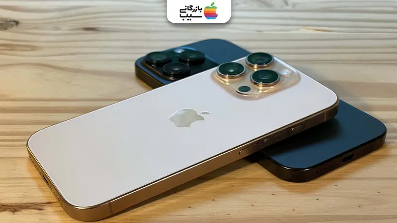 تصویری از دو گوشی آیفون 16 پرو مشکی و صحرایی در کنار هم روی میز
