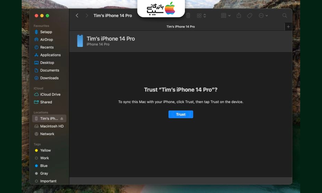 تصویر اتصال آیفون به مک با کابل اصلی از مراحل آموزش تهیه نسخه پشتیبان (Backup) روی مک قبل از آماده‌سازی آیفون برای نصب iOS 26