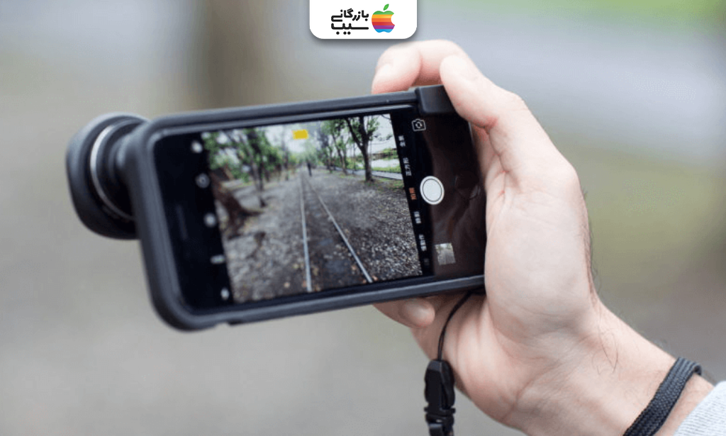 تصویری از فردی در حال عکاسی با آیفون همراه با لنز